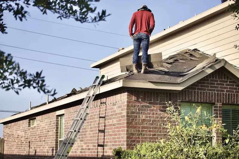 Professional roofer working on a residential roof in Saddle Rock Golf Club